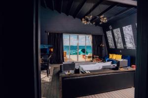 Oaga Art Resort Maldives - Greatest All Inclusive في نورث ماليه آتول: غرفة معيشة مطلة على المحيط