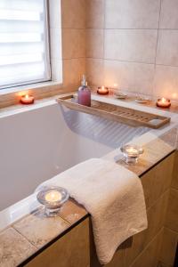 uma casa de banho com uma banheira com velas e uma toalha em Apartament Przytulny 3 km od Wadowic em Chocznia