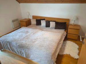 um quarto com uma cama grande e um cobertor branco em Apartment ANDA em Bad Kleinkirchheim