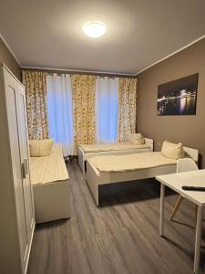 Kleines Zimmer mit 2 Betten und einem Tisch in der Unterkunft Arsi Hostel in Hamburg