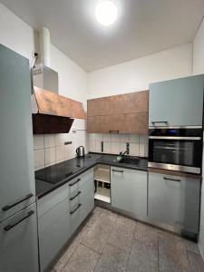eine Küche mit Küchengeräten aus Edelstahl und schwarzen Arbeitsplatten in der Unterkunft Arsi Hostel in Hamburg
