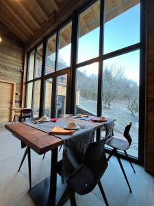 een houten tafel in een kamer met een groot raam bij La Grange des Eulets in Bourg-Saint-Maurice