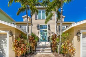 uma casa com palmeiras em frente em Coconut Cottage em Holmes Beach