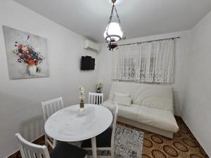 un salon avec une table blanche et un canapé dans l'établissement Apartman Šparović u blizini Porto Novog Kumbor, à Ðenovići