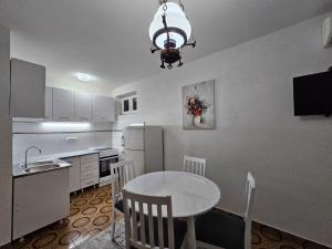 une cuisine avec une table, des chaises et un évier dans l'établissement Apartman Šparović u blizini Porto Novog Kumbor, à Ðenovići