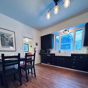 a kitchen with black cabinets and a table and chairs at The Downtown Hive by Revelstoke Vacations in Revelstoke
