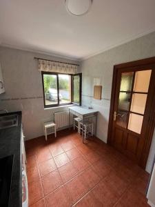 une cuisine avec une table, une fenêtre et une table dans l'établissement Casa Musoles, à Comillas