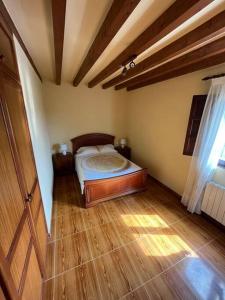 um quarto com uma cama e piso em madeira em Casa Musoles em Comillas