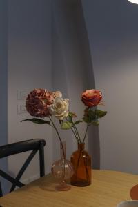 two roses in a vase on a table at CasaMancio, loft in heart of medieval Tuscan city in Pistoia