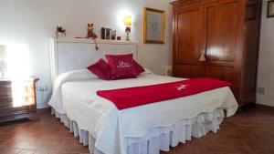 a bedroom with a bed with red pillows on it at Appartamenti La Rocca in Palaia