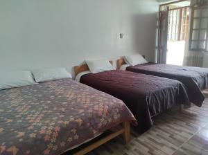 Кровать или кровати в номере Hospedaje Pinky Lodge