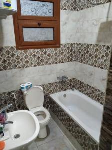 uma casa de banho com um WC, um lavatório e uma banheira em Duck Nest (Kak Kak) no Cairo