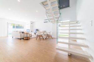 - un escalier blanc dans le salon avec un canapé dans l'établissement Villa Beija Flor, à Charneca