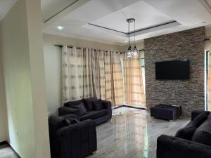 uma sala de estar com dois sofás e uma televisão em Steady State Apartment 1 em Lusaka