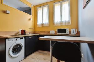 a laundry room with a sink and a washing machine at Nice studio with garden near Paris in Vanves - Welkeys in Vanves