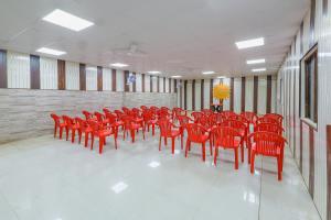 a row of red chairs in a large room at Mud House by ChanchalRani in Rāmnagar