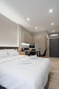 een groot wit bed in een kamer met een keuken bij d Suites and Apartments in Ioannina