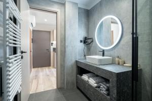a bathroom with a sink and a mirror at d Suites and Apartments in Ioannina