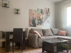 a living room with a couch and a table at Alacaster G apartman in Novi Sad