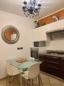 eine Küche mit einem Tisch, Stühlen und einem Kronleuchter in der Unterkunft San Lorenzo 66 in San Giovanni Valdarno