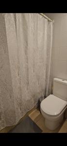 uma casa de banho com um WC e uma cortina de chuveiro em Depa La Cisterna em Santiago