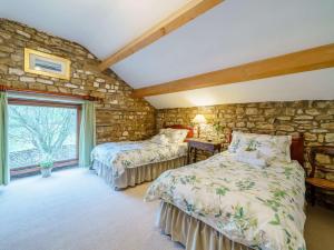 1 Schlafzimmer mit 2 Betten und einer Steinmauer in der Unterkunft 2 Bed in Sedbergh 57641 in Dent