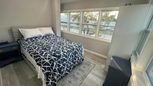 um quarto com uma cama com um edredão preto e branco em Our Nest - Historic Ybor City em Tampa