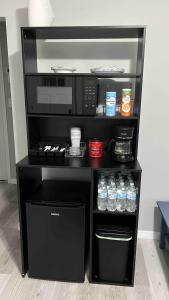 a black microwave oven on a stand with drinks at Our Nest - Historic Ybor City in Tampa