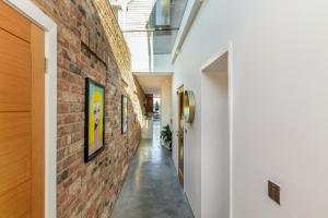 a hallway of a house with a brick wall at Nutkin Barn - Contemporary home in West Sussex in Chichester