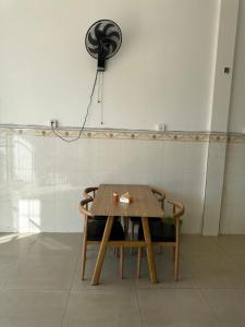 uma mesa de madeira com 2 cadeiras e uma ventoinha em Everest Restaurant and Guest House em Sihanoukville