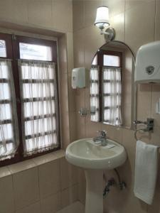 y baño con lavabo y espejo. en Suites+Arte, en Quito
