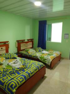 1 dormitorio con 2 camas y ventana en HOTEL KIRPAS, en Villavicencio