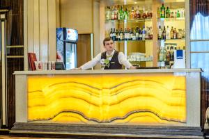a man standing behind a yellow counter in a bar at SK Royal Hotel Moscow in Moscow