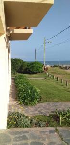 a porch of a house with a field of grass at Tritones Playa in Pinamar