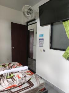 Zimmer mit einem Bett und einem Flachbild-TV in der Unterkunft HOTEL KIRPAS in Villavicencio