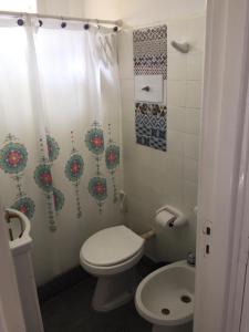 a bathroom with a toilet and a shower curtain at Tritones Playa in Pinamar