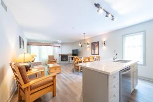 een keuken en een woonkamer met een tafel en stoelen bij Horseshoe Valley Suites - The Verdant in Shanty Bay