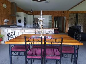 a wooden dining room table with chairs around it at Ahaura Lodge & Waterwheel Farm Stay in Totara Flat