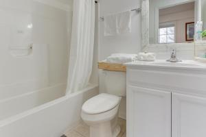 a white bathroom with a toilet and a sink at Cozy Inwood Apartment History, Hiking and Wine! in Inwood +16 photos