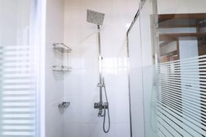 een badkamer met een douche met een douchekop bij The Rusororo Residence in Kigali