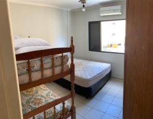 1 dormitorio con 2 literas y ventana en Apartamento Guarujá 5min a pé da Praia da Enseada, en Guarujá