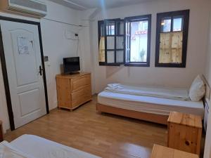 una camera con due letti e una televisione e una porta di Кедър 5 a Dolna Banya
