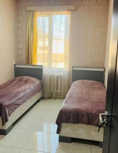 2 camas en un dormitorio con ventana en Cosy Ijevan, en Ijevan