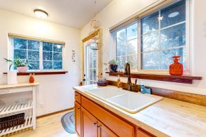 a kitchen with a sink and two windows at Hearthwood in Fort Bragg +14 photos