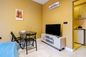 a living room with a tv and a table and a kitchen at Studio Flat 6 min to Yedikule Fortress in Fatih in Istanbul