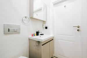 a bathroom with a sink and a white door at Studio Flat 6 min to Yedikule Fortress in Fatih in Istanbul