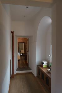 Cette chambre dispose d'un couloir avec un lit et une table. dans l'établissement CasaMancio, loft in heart of medieval Tuscan city, à Pistoia