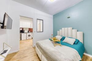 een slaapkamer met een groot bed en een tafel. bij Guest Loc - 10min Paris - Oasis de Paix - Netflix in Villejuif