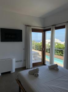 a bedroom with a bed and a sliding glass door at Villa d'Es Bot in Cala Morell