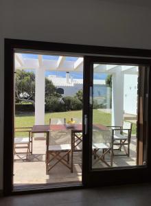 una porta a vetri che conduce a un patio con tavolo e sedie di Villa d'Es Bot a Cala Morell
